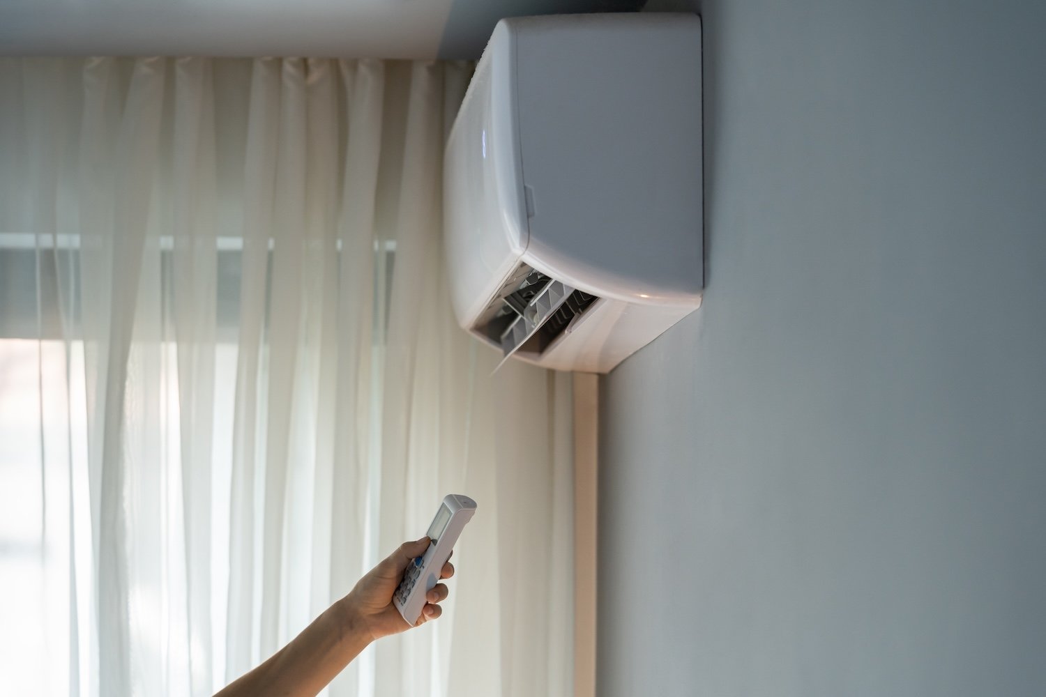 Aire acondicionado tipo split residencial encendido con control remoto